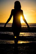 female Silhouette on Beach at setting Sun