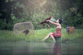 woman with chicken by the river