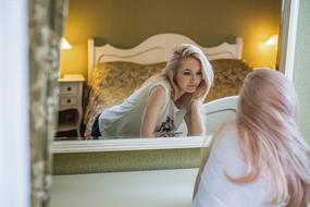 beautiful blonde posing near the mirror in the bedroom