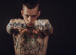 photo of a guy with tattoos and rings