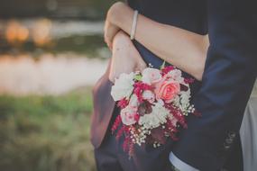 Bride and groom, with the colorful and beautiful bouquet, with the flowers, on the wedding