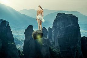 sexy Woman standing on rock at sunrise, fantasy