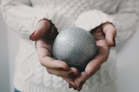 silver ball in the hands of a girl close-up