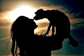 girl with dog in hands at Backlight, Silhouette