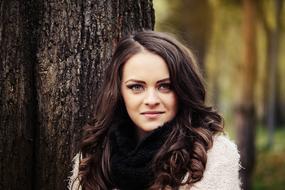 brunette in autumn park on wood background