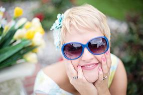 happy woman in sunglasses on blurred background