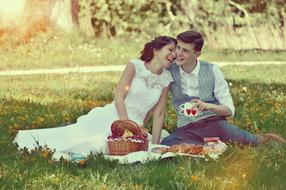 young happy Wedding Couple sit on lawn, picnic