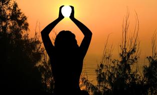 silhouette of woman Holding sun at water