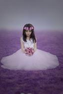 Little colorful girl on the violet grass