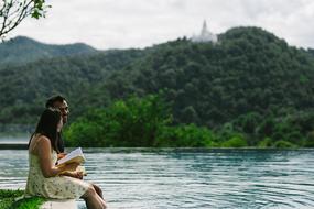 couple on the seashore reading a book, chiang mai, thailand