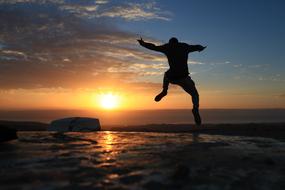 Happy man on coast at Morning Sunrise