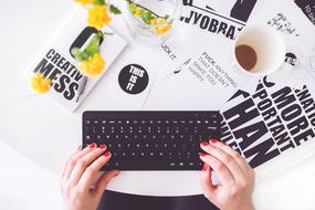 palms of Girl Typing on black keyboard