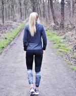 blonde Woman walking away on path in park