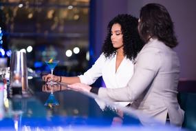 man and Black Girl with drink in Bar