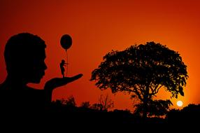 Silhouettes of the people with balloon, and tree on the landscape, at colorful and beautiful sunset, clipart