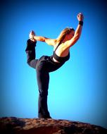 stretching woman on the top of a rock