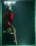 young woman in red dress posing Underwater