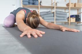 young girl doing Yoga pose on floor