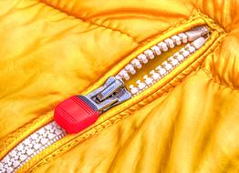 macro photo of a zipper on a yellow jacket