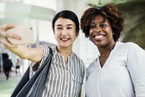 African and Asian women taking selfie together