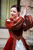 young woman in Medieval costume dancing on street