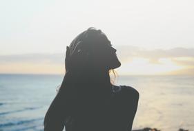 woman posing near water in blurred background