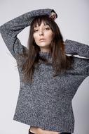girl in a sweater posing in the studio