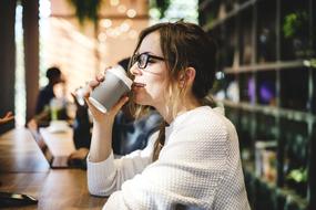 girl drinks cappuccino at the bar