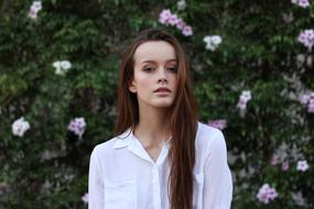beautiful girl on the background of a flowering bush