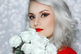 photo of polar blonde with a bouquet of white roses