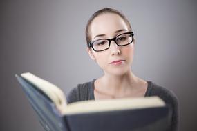 girl in glasses reading book