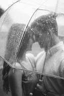 young Couple in love beneath transparent umbrella