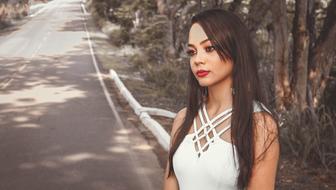 a girl in a white blouse stands on the road