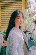 young asian girl at window with potted plants on sill