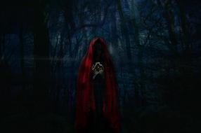 girl in a red cloak in a dark forest