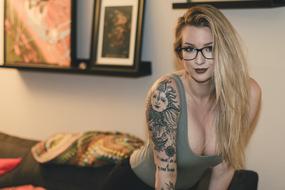 Woman with the glasses and tattoos