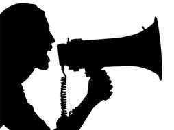 silhouette of a man screaming into a loudspeaker