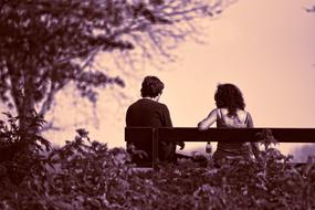 monochrome photo of a couple sitting on a bench
