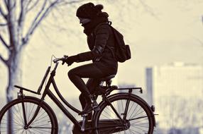 black and white photo of a cyclist in the park