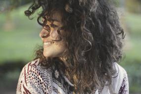 profile portrait of happy woman with curly hair