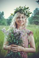 girl with a wreath on her head holding a bouquet of flowers