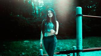 Beautiful girl, wearing jeans with high waist, near the trees, in Moscow, Russia, in turquoise light