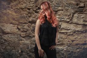 girl with beautiful long hair posing near the wall