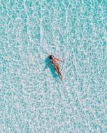 distant top vie of woman relaxing on water