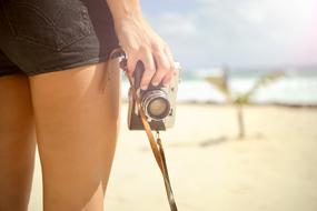 girl with vintage camera on the sandy beach