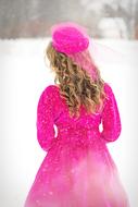 curly girl in pink clothes in winter