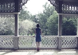 picture of Woman on wooden terrace looking at blooming garden