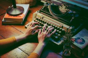 female hands on vintage typewriter