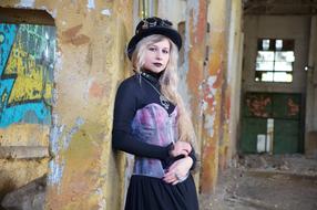 steampunk girl posing at grunge wall