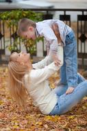 Mom and Son playing on fallen leaves